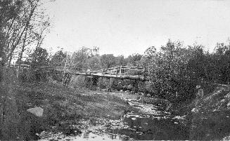 Image shows a wooden bridge over Don river, Toronto, Ontario. 