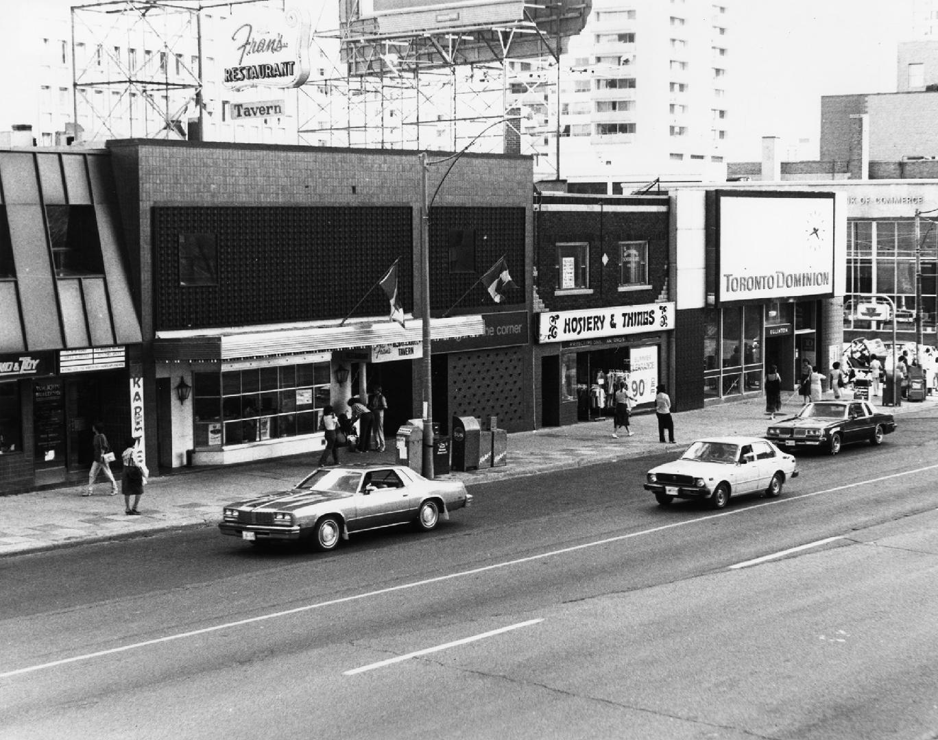 Yonge-Eglinton Intersection, east side of Yonge. Image shows mostly Yonge street and a few cars ...