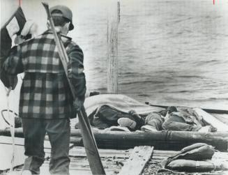Bodies of three studens are covered by tarpaulin on the dock of Topping Lodge where both survivors and victims of Sunday s Lake Timiskaming tragedy we(...)