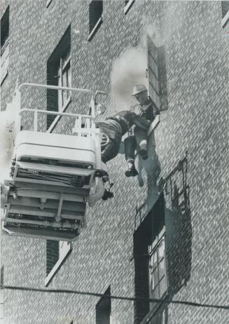 Smoke pours from window of the Ford Hotel yesterday as fireman on hydraulic ladder leans forward to rescue guest perched on seventh-floor window ledge(...)