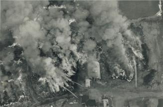 Dense Cloud: Billowing smoke and flames engulf a storage shed at dump where tires have been burning 14 days despite a herculean effort to douse the blaze