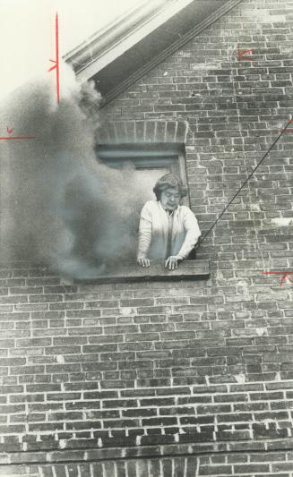 Heather Douglas, 20, leans out third-floor window as smoke billows