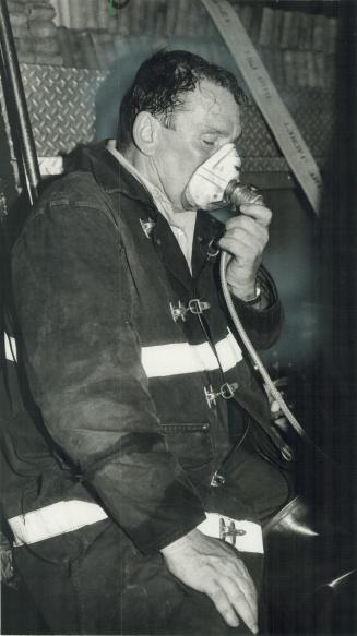 Arsonist s victims: Fire captain James Coles, left, breathes oxygen after being overcome by smoke while fighting fires set by an arsonist at the Harbour Castle Hilton last night