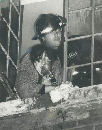 Breath of life. A fireman gives oxygen to a woman before helping her from a Homewood Ave. apartment fire yesterday. More than 30 tenants stayed in a T(...)