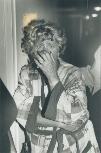 A firefighter, left, carries out charred furniture as a distraught Doreen Swergosh, right, weeps in the lobby of a Triller Ave, building after fleeing(...)