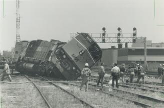 Getting back on track. Firefighters clean up spilled diesel fuel yesterday after two train engines derailed shortly after noon when tracks gave way in(...)