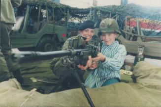 No life like it. Ian Giraudy, 10, gets a close look at a C9 auto machine gun with Corporal Marcia Kellis as the Governor General's Horse Guards Regime(...)