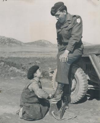 PTE. Claire Cleaves, Eyebrow, Saskk., gets boots shined by South Korean lad. Canadian have adopted a Korean boy for the price of one chocolate bar