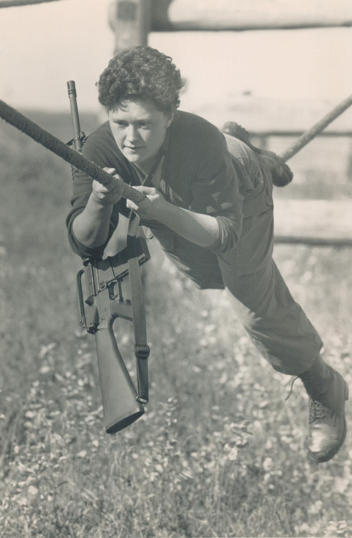 Hanging tough: Teena Harris performs the Australian Death Crawl, above, while Shelly Harris, foreground, right, an Lisa Butterworth practise on firing range