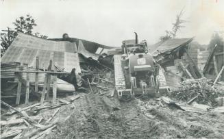 Clearing the way for the proposed Pickering airport, Tom Gretton rams his bulldozer into an old shed north of Brougham yesterday and goes right up on (...)