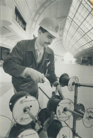 A grand airport hall. Electrician Arthur Verway wires up the check-in counters in the Grand Hall of Terminal 3 at Pearson International Airport. The t(...)