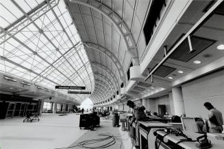 Preparing for takeoff. Check-in counters in the Grand Hall of Terminal 3 at Pearson International Airport are being finished and wired for the opening(...)