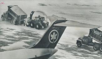 Snow streams up into the air from the funnel of a snowblower at Toronto International Airport as it waits for an empty truck to move into position to (...)