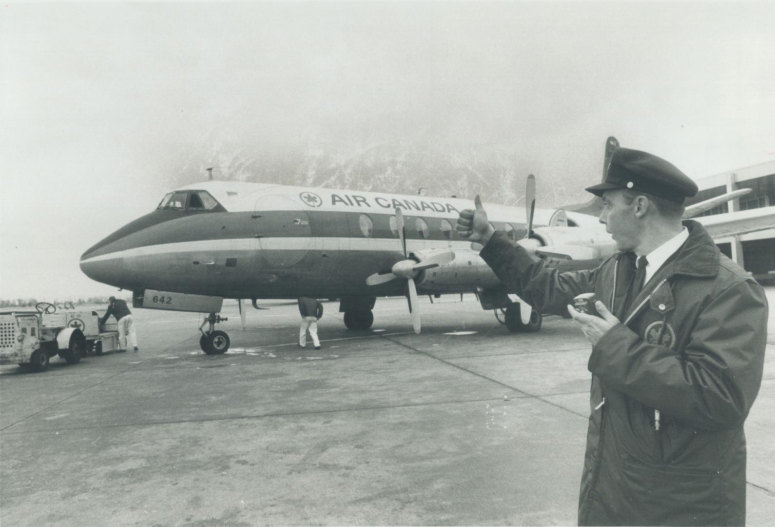 Loading ramp supervisor Jack Belanger gives pilot the 'Ready to go' Sign