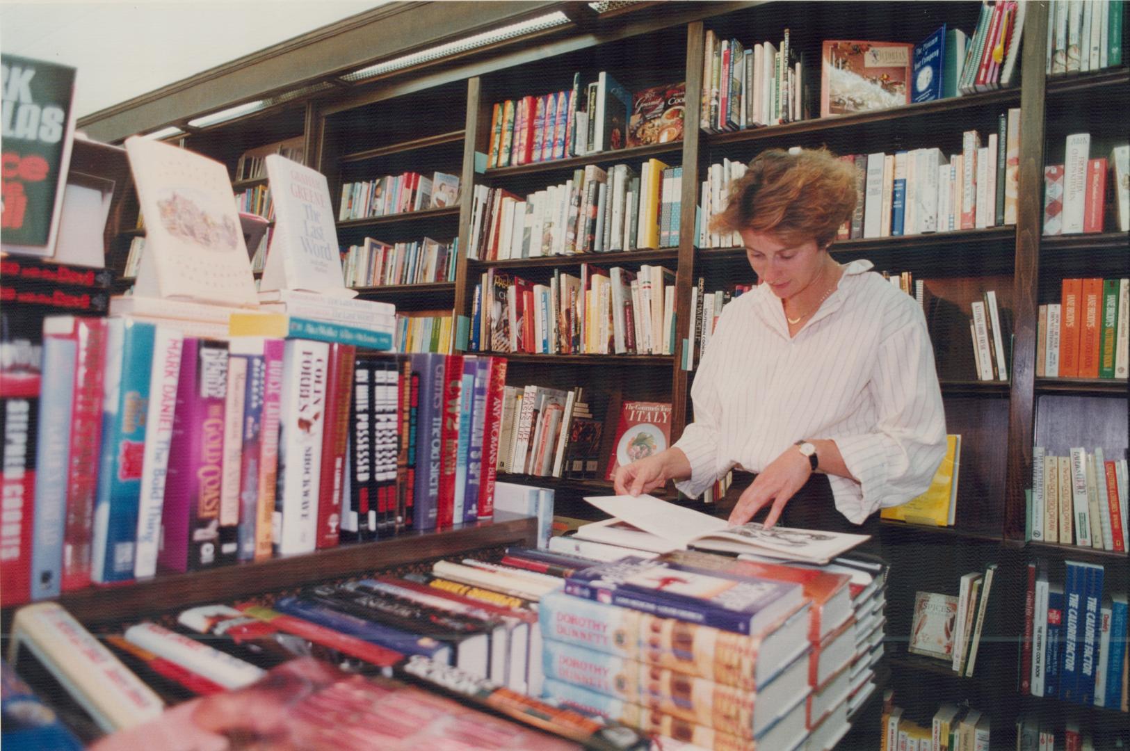 Colette Robert browses at a tablestop display in Britnell's Book Shop On Yonge St