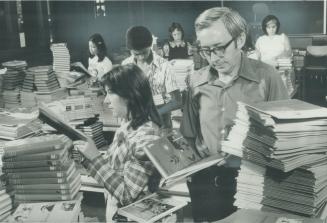 Stacks of textbooks at the new Eastdale school in Toronto are checked by principal Bob Beardsley and Debby Bowen