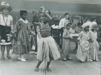 Caribana '67 - in Miniature, Her grass skirt swaying to the beat of a calypso band, Chandra Galasso, 7, was one of 10 youngsters dancing yesterday in (...)