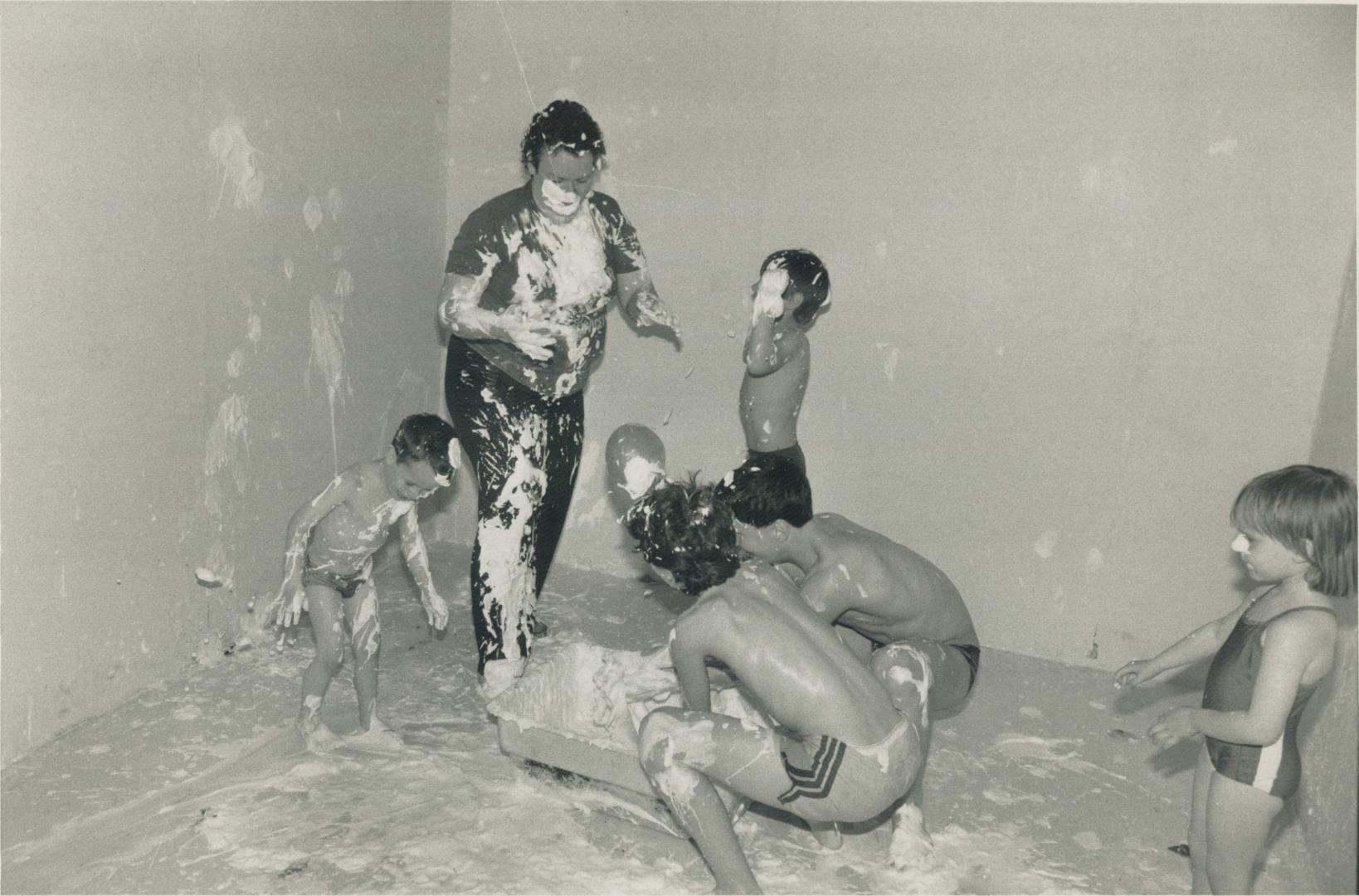 Happy birthday: Helen Bell, manager of the Mad Hatter, gets dirty with a group of youngsters during a whipped cream fight at one of the establishment's regular parties