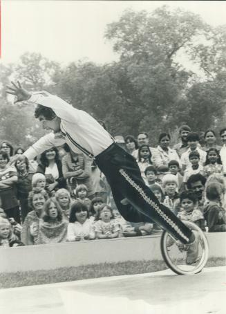 Clowning around. John Kerwich of Puck's Mini-Circus fakes a fall from his unicycle to the delight of his young audience on Toronto Island yesterday. K(...)