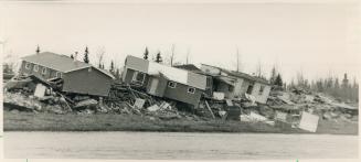 Crushed by ice: Buckled houses and rubble along the Winisk River are a sad reminder of spring flooding that destroyed all but seven of the Cree village's 60 buildings two weeks ago