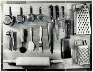 Catalogue of utensils displayed on a chopping block, all from Pampered Kitchens, includes stainless steel dry measuring cups, high carbon, stainless s(...)