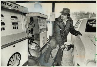 Station attendant Ally Hossain fills up tank of gas for customer