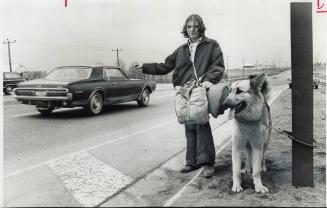 'Take me...Take my dog'. With his packsack and German shepherd, Lucky, 18-year-old Joe Salmon, of Rexdale, stands at highways 10 and 401, hitch hiking(...)