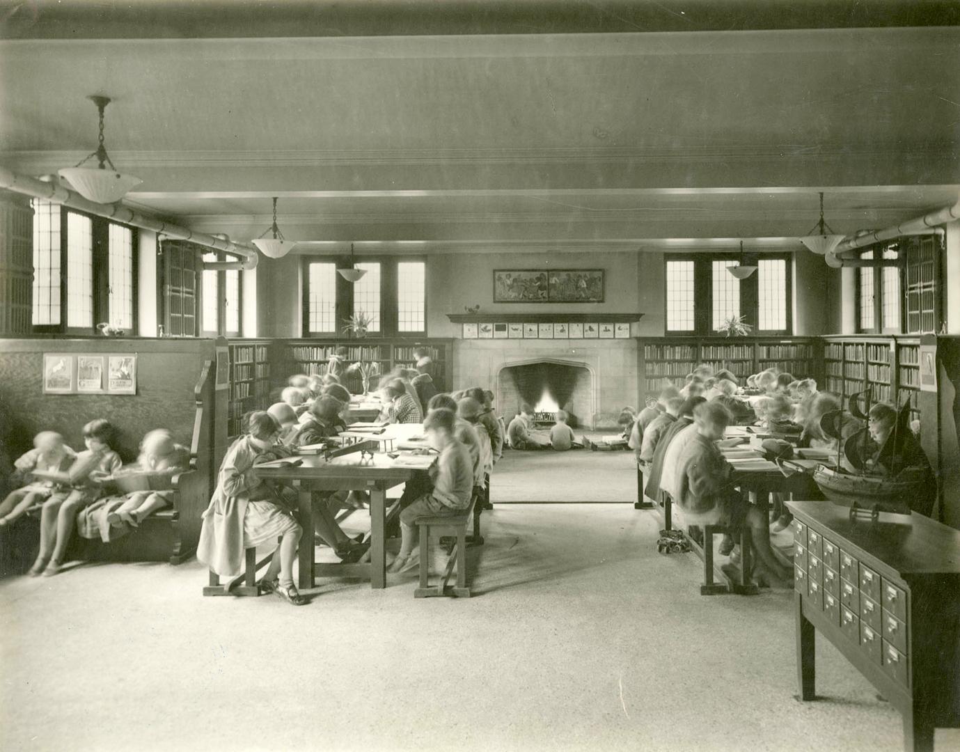 Image shows an interior of the branch. There are a lot of children sitting at the desks.