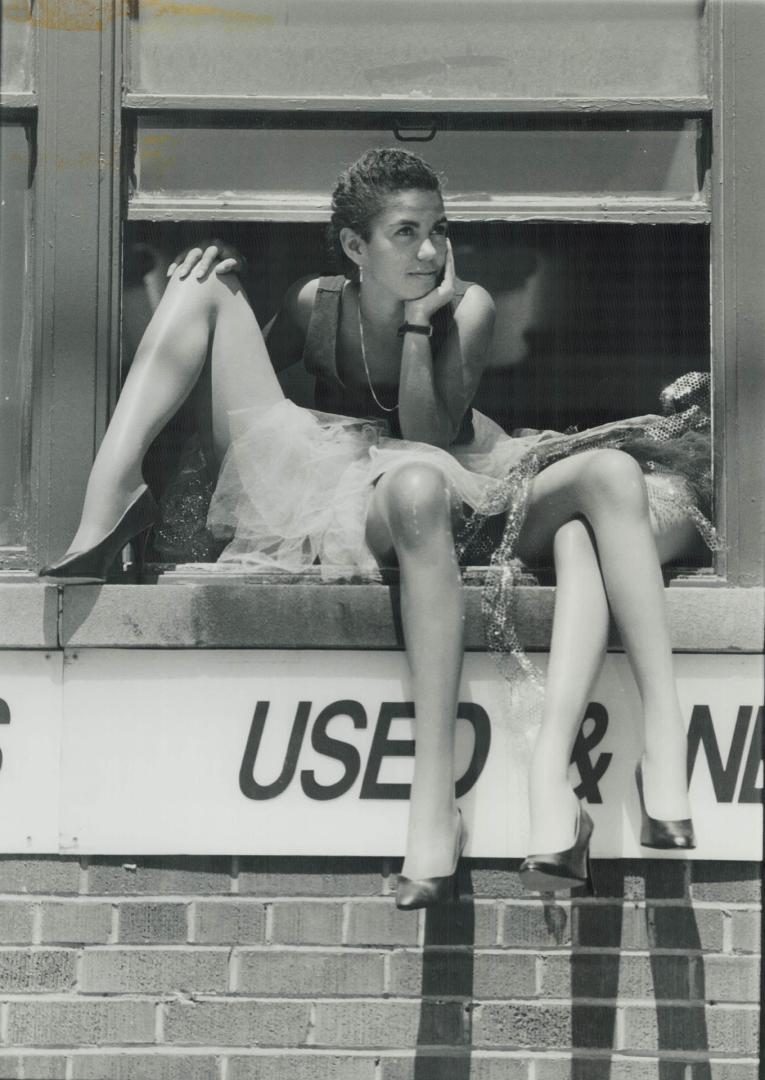 Out on a limb, Eunice DeOliveira, 25, of Barrie gazes out the second-floor window of Conlyn Displays on Adelaide St