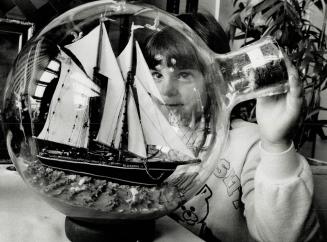 Nose To The Bluenose, Alanna Hager, 6, holds close a bottle containing a model of the Bluenose II for a stem-to-stern look yesterday. George Fulfit, 8(...)