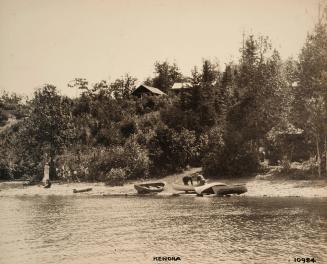 Nipigon 10984 [canoes on beach below cabins]