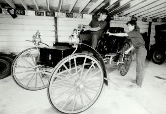 Art Carty and Peter Fawcett (right) work on a 1909 Holsman High Wheeler