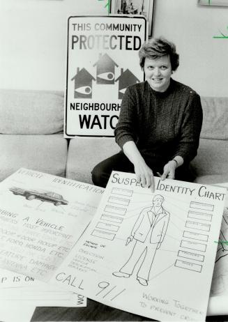 A challenge: Carol Johnson poses with some of the promotional charts she has designed as a Neighborhood Watch volunteer