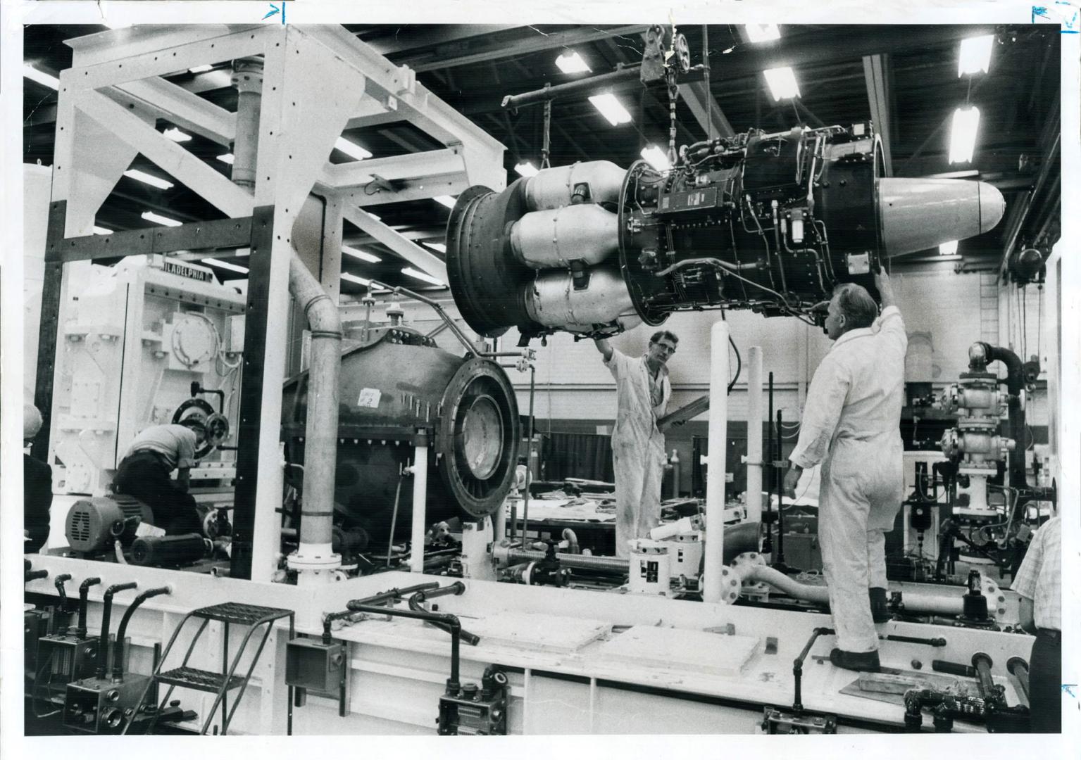 Canadian Powerplant for Arabian Oil, Big 6,000-horsepower industrial gas turbine is lowered gently by Harry Rudge (at controls) and Joe Chapman into o(...)