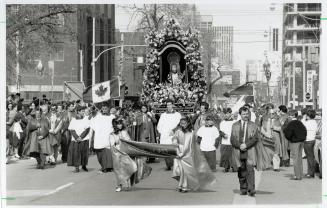 Portuguese parade: The figure of Christ is carried in a procession to Portugal Square in the Bathurst-Adelaide area of Toronto in yesterday's Santo Cristo Parade