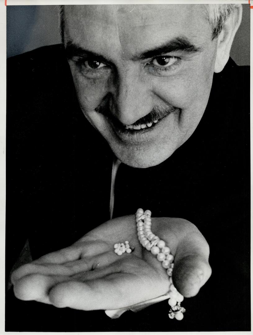 Gerald Keeley with his pearls, He holds wife's bracelet for comparison in size