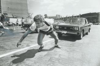 Herculean task: Paul Mitchell of Halifax grits his teeth and strains in the car-pull, part of challenge fitness tests being held yesterday and today at the CN Tower