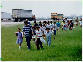 Some Trip! Public school students on an excursion walk to another bus yesterday after theirs was stuck for four hours by the truckers' protest. The students were returned to their school