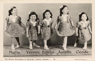 Black and white picture of five identical little girls in matching party dresses.