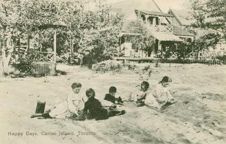 Black and white photograph of five children playing in the sand in front of two Victorian cotta ...