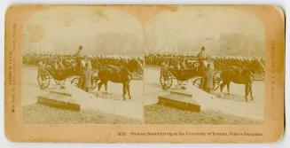 Pictures show a large group of people standing and watching as horse drawn coach with dignitari ...