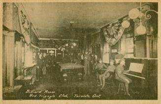 Black and white photograph of men in uniform posing around a pool table and piano.