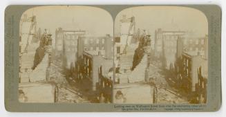 Pictures show a man on a rooftop looking down onto a street of fire ravaged buildings.