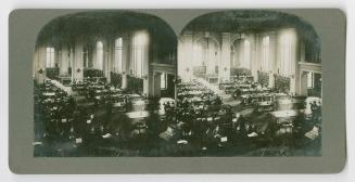 Pictures show two rows of long wooden tables with people sitting at them reading.