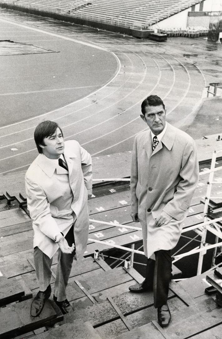 Dennis Mills (left), with his father, Alfred Mills, are standing on the extra seating their company installed at the CNE Stadium for the Grey Cup game(...)