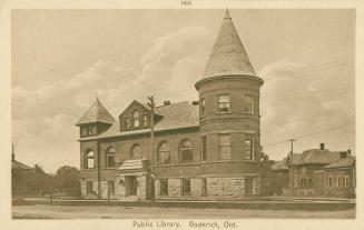 Picture of library with large three story tower and houses on the left. 