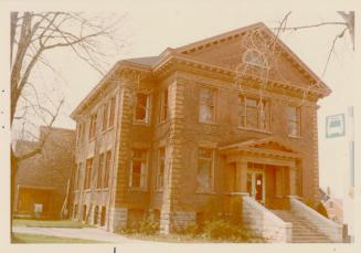 Photo of large two storey brick public library building. 