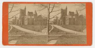 Pictures show a huge collegial gothic style building behind roads, lawns; picket fence in the f ...