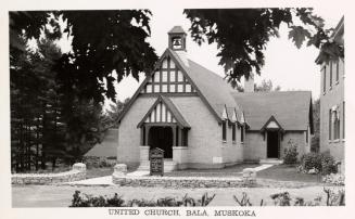 Black and white picture of a small county, brick church.