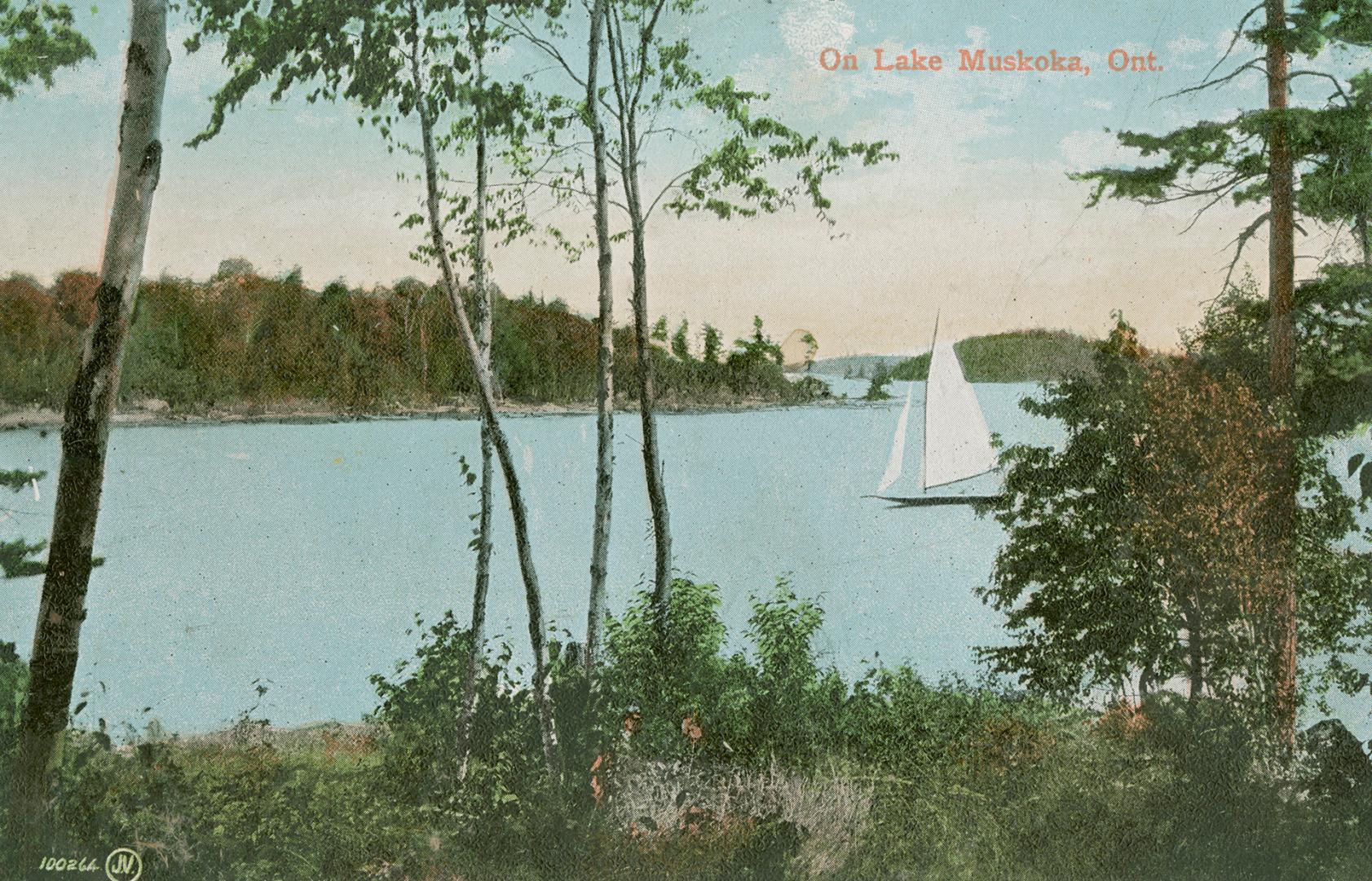 A sailboat on a large lake in the wilderness.